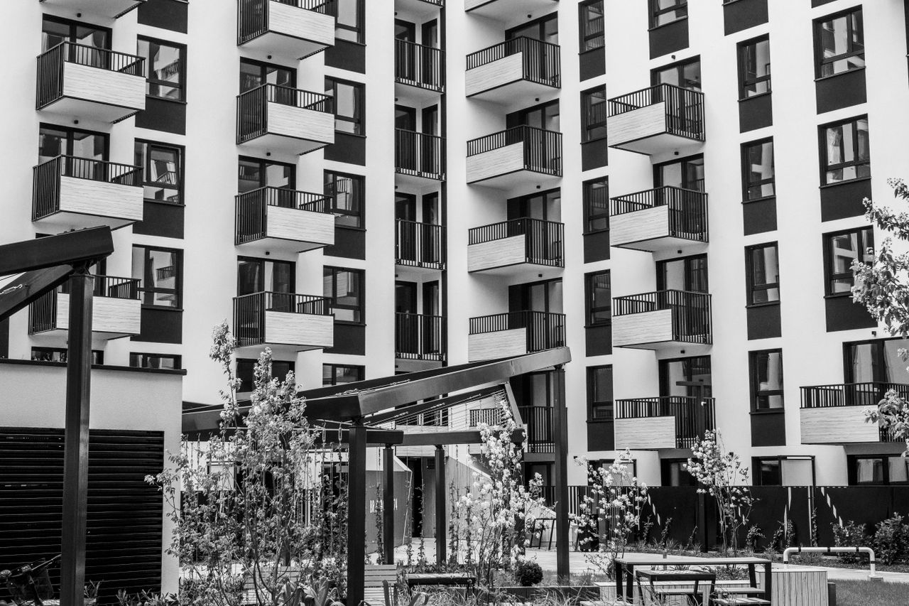 Contemporary urban apartment building with balconies and courtyard, black and white.