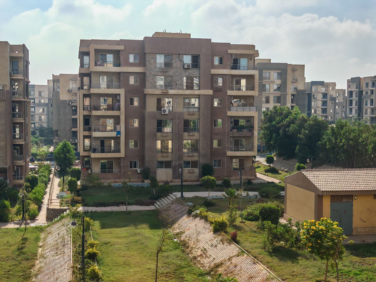 About Aerial view of residential apartment buildings surrounded by greenery.